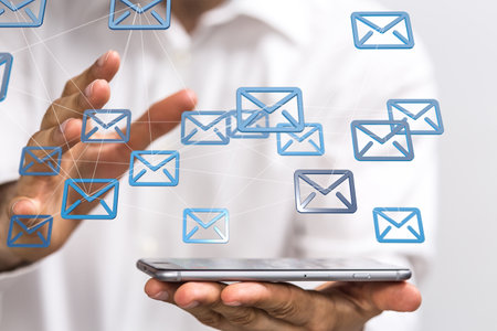 A 3D rendering of email icons floating on a man's tablet - Concept of business communicationの写真素材