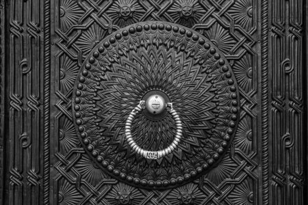 A closeup of a vintage old metal door with knockerの写真素材