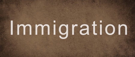 The world immigration is standing on a brown colored wall, refugees Europe, asylem seekers, immigrantの写真素材
