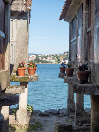 A View of the sea between two old sunny buildings of Combarro in Galicia, Spain on a sunny dayの写真素材