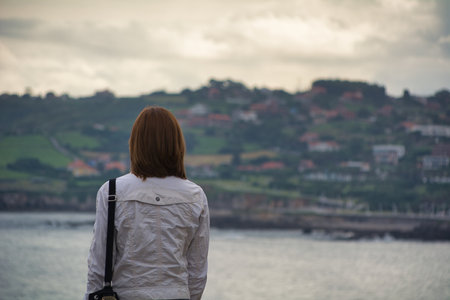 A closeup of a woman from behind looking at the buildingsの写真素材