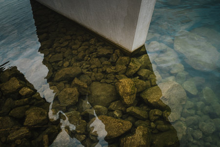A stone pillar in the water with reflections