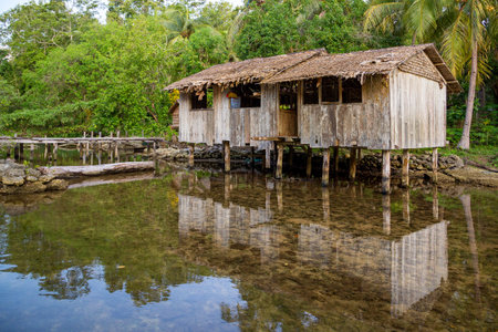 A thatched-roofed house built over the waters of Marovo Lagoon, a large salt water lagoon in Western...