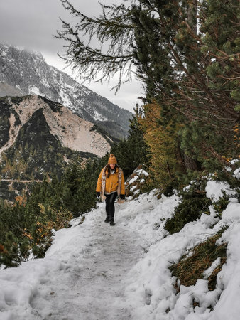 A vertical shot of the young female on the background of the Julian Alps in the winter in Sloveniaの写真素材