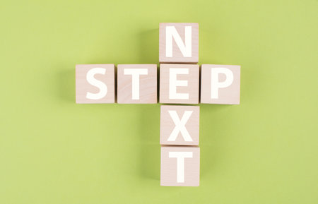 Crossword with next step, planing new strategy, setting a goal,green colored backgroundの写真素材