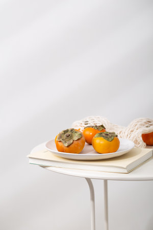 A closeup shot of persimmon fruits on plateの写真素材