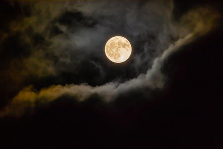 A fascinating shot of the full moon through the clouds