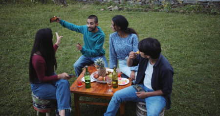 A group of Indian friends taking a selfie during a party in the gardenの写真素材