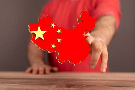 A finger touching a digital illustration of china map flagの写真素材