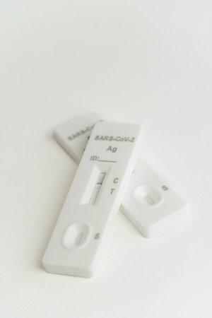A vertical shot of rapid COVID tests on a white surface