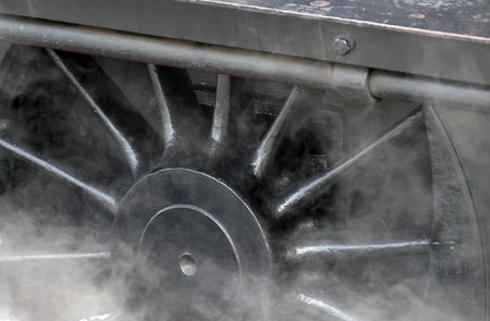 The steam around the metal wheel of a steam train at Grosmont Station in the UK