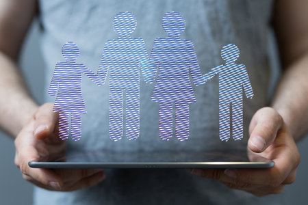 A hologram of a family floating on the tablet being held by a personの写真素材