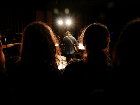 The guitarist in a concert. View behind people's silhouettes.の写真素材