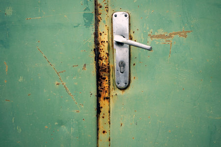 A closeup of a handle on a rusted metal doorの写真素材