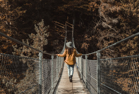 A close-up shot of a woman standing on a suspension footbridge in Kranjska Gora, Slovenia on a sunny dayの写真素材