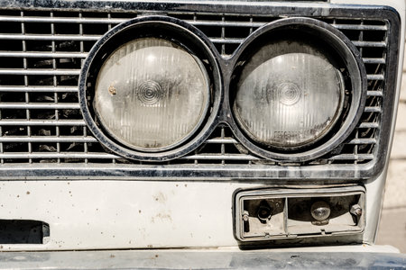 A closeup of an old head light of a gray car