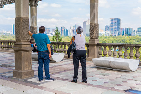 Two tourists in Chapultepec Castle with skyscrapers in the background