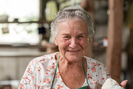 A smiling Hispanic elderly woman in a wooden house in Tilaran, Guanacaste, Costa Ricaの写真素材