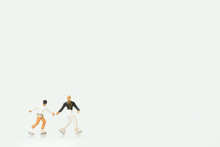 Two miniature figures of ice skaters on a white background