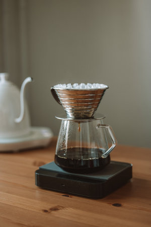 A vertical shot of a manual brewer machine with fresh coffee on the wooden tableの写真素材