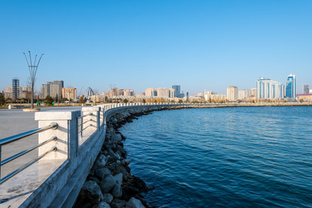 A beautiful scene of the sea by the fence with a blue sunny sky on the horizon in Baku, Azerbaijanの写真素材