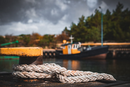 A selective focus shot of a fishing rope near a gloomy harborの写真素材