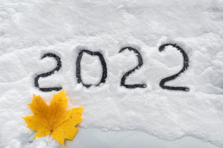 On freshly fallen white and clear snow, the number 2022 is written - the date of the next New Year....