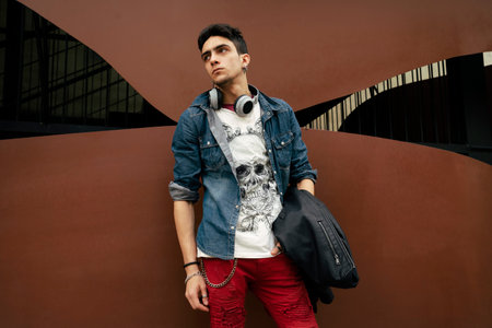 A cool young Caucasian guy from Spain posing in an urban outfit in Valencia, Spain
