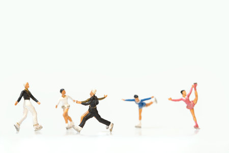 A group of miniature figures of ice skaters on a white backgroundの写真素材