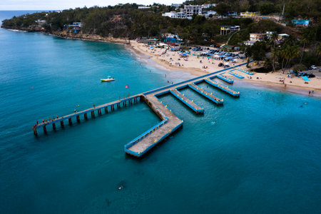 An aerial view of a turquoise sea with piers, coastline trees and buildingsのeditorial素材