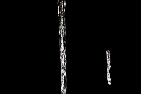 A selective focus shot of icicles on black backgroundの写真素材