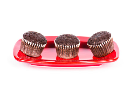 A closeup of the freshly baked muffins on the plate isolated on the white backgroundの写真素材