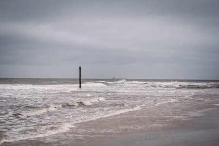 A closeup shot of foam waves hitting a seashoreの写真素材
