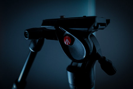 A closeup shot of a camera tripod on a blurred background