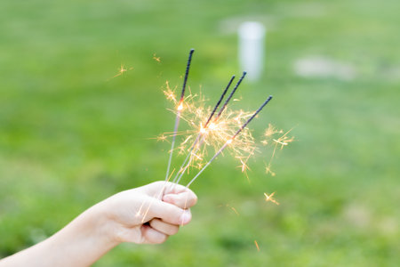 A selective focus shot of a girl's hand holding sparklers