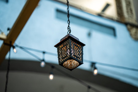 A decorative lantern hanging on a wooden ceiling outdoorsの写真素材