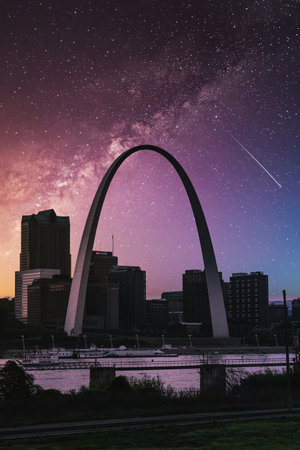 A vertical shot of St. Louis Gateway Arch and skyscrapers in Missouri, USA at night time