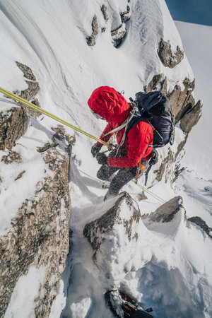 Winter mountaineering, alpinism in Mont Blanc Masiff, France. An alpinist descending on a rope from a mountain.の写真素材