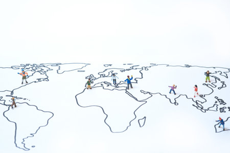 Small miniature children of different origins spread out on a world mapの写真素材