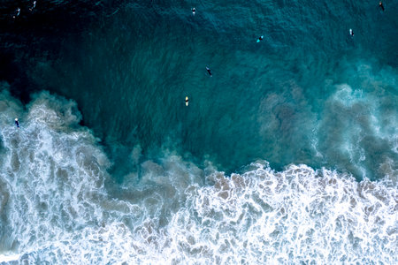 An aerial view of surfers riding the waves in Newport Beach, California