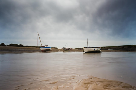 Low shot, of Boats at low tide on the River Burn, Norfolkの写真素材