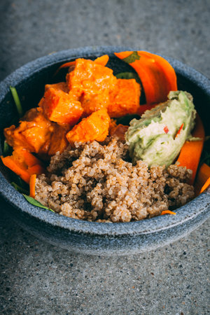A vertical shot of a healthy quinoa bowl with vegetables