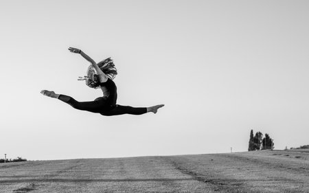 A grayscale of a ballerina in the air