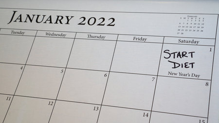 A selective focus shot of a calendar reminder about the resolution to start a diet on New Year