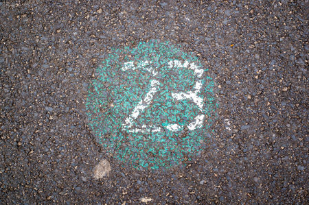 A top view of white spray paint number 23 on the asphalt groundの写真素材
