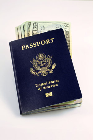 A vertical shot of an American passport with dollar bills on a white backgroundの写真素材
