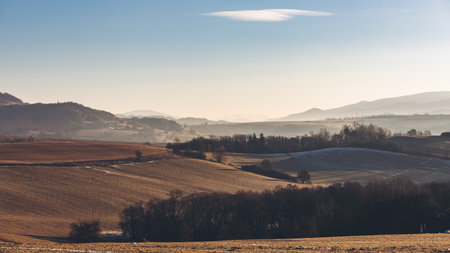 An orange scene landscape of the snowy mountain and trees in Banska Bystrica in Slovakia at sunset