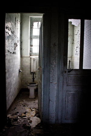 A vertical shot of the bathroom interior in an abandoned houseの写真素材