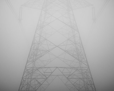 The high voltage transmission tower under fog