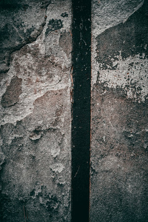 A vertical shot of a weathered rustic textured wall with a black dark gap in betweenの写真素材